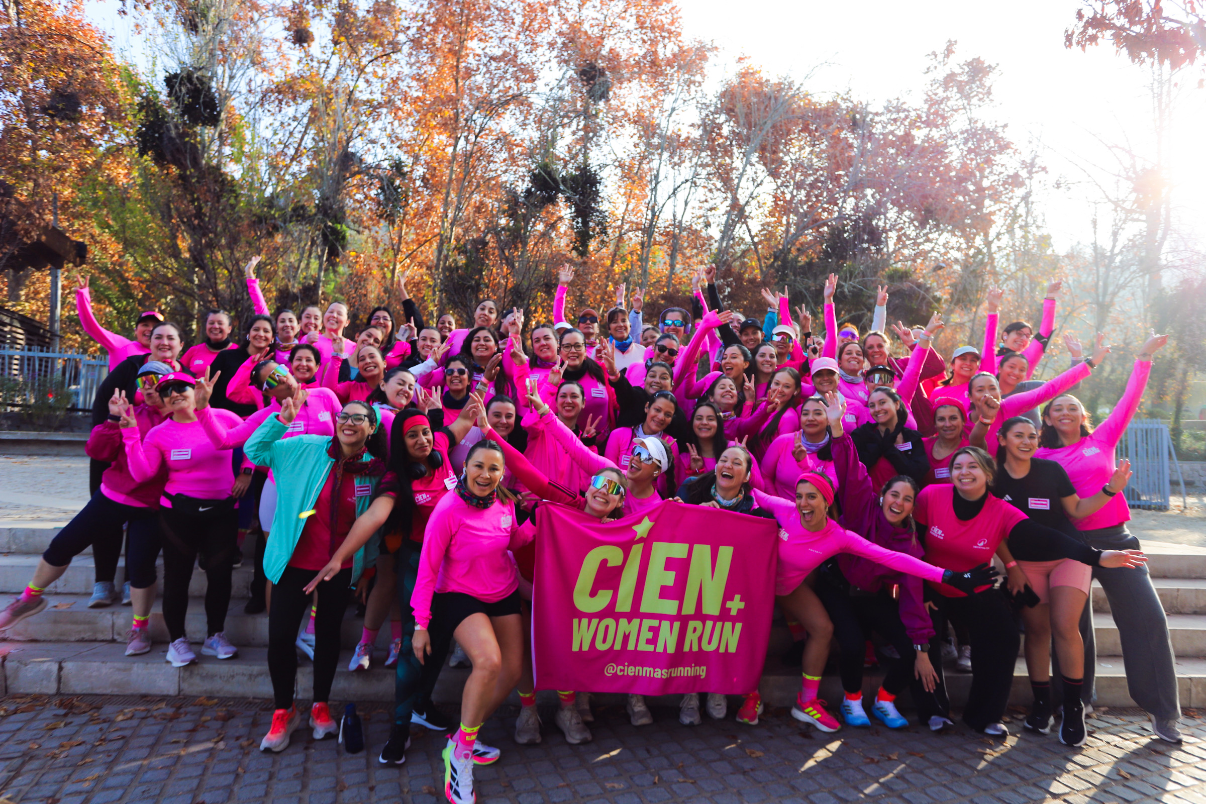 Corredoras CIEN+ reunidas con poleras rosadas